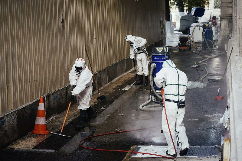 Workers clean up a lead-contaminated area near Notre Dame Cathedral in Paris on Sept. 2. The fire April 15 at the cathedral spread clouds of lead dust that officials were slow to deal with, an investigation shows. 