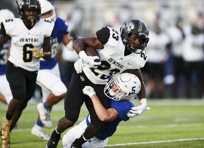 Little Rock Central running back Sam Franklin (23) is tackled by Jordan McKibbon of Rogers during the Tigers’ 42-25 victory on Friday in Rogers. For more photos, go to arkansasonline.com/914central/. 