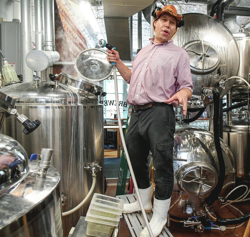 Zac Smith, co-owner of SQZBX Brewery and Pizza Joint, explains the beer-making process. - Photo by Grace Brown