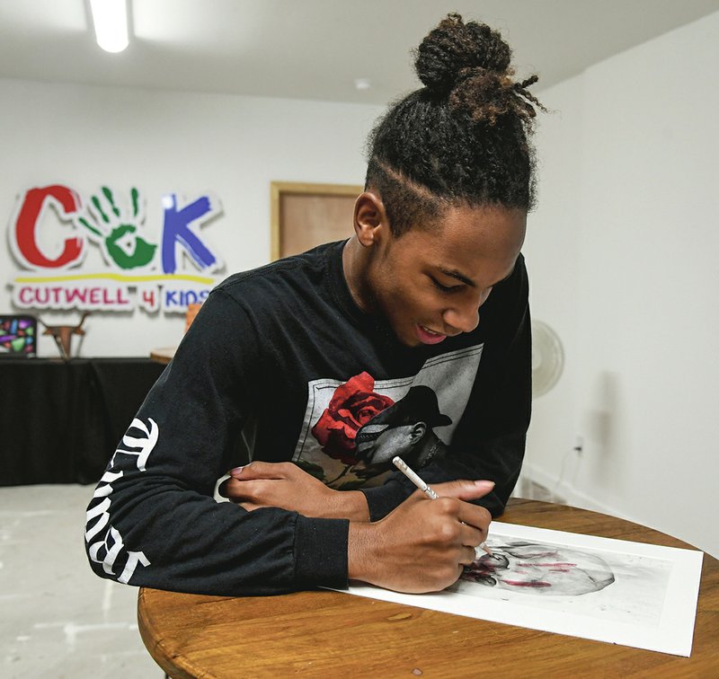 Artist James Avery touches up a previous piece of work at Cutwell 4 Kids. -Photo by Grace Brown