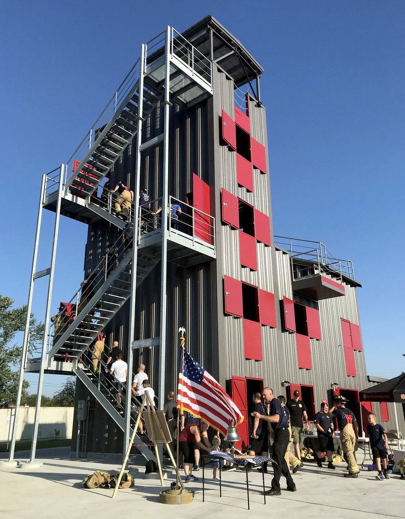 Janelle Jessen/Siloam Sunday Siloam Springs firefighters climbed more than 2,000 steps, or the equivalent of 110 flights of stairs, in the department's new training tower on Wednesday morning in memory of the firefighters who climbed the World Trade Center towers on 9/11 to rescue the civilians inside. The Siloam Springs firefighters were joined by members of the Siloam Springs Police Department and the West Siloam Springs (Okla.) Fire Department. After each firefighter and police officer finished their climb, they rang a bell and read the name of a firefighter or police officer who died in 9/11.