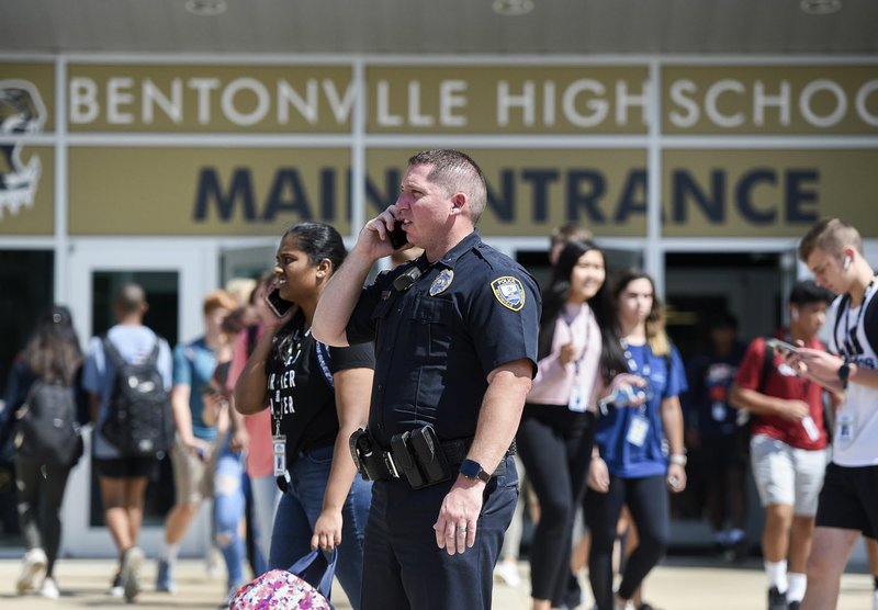 NWA Democrat-Gazette/CHARLIE KAIJO Student Resource Officer John Loncarevic monitors students Thursday at the end of the school day at Bentonville High School.