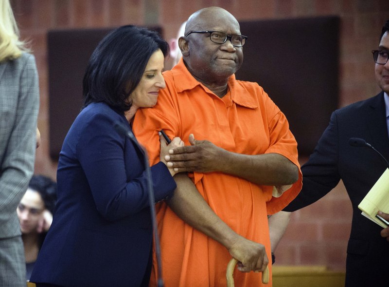 FILE - In this June 8, 2017 file photo, Innocence Project lawyer Vanessa Potkin, left, hugs Alfred Swinton, in Superior Court in Hartford, Conn. Swinton served almost two decades in prison for the 1991 killing of Carla Terry before he was cleared based on new DNA evidence. Several states have moved to toughen regulations on the use of jailhouse informants. Advocates said Swinton's erroneous conviction was based in part on the testimony of lying inmates. (Mark Mirko/Hartford Courant via AP, Pool, File)