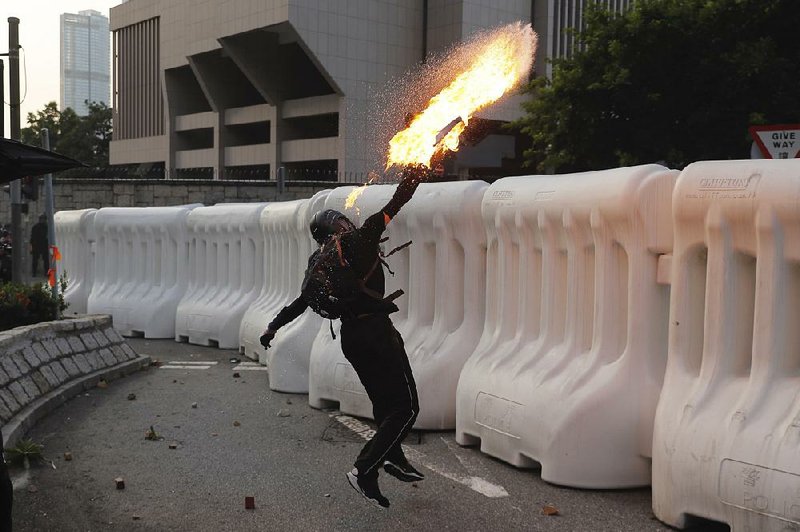 An anti-government protester throws a Molotov cocktail during a demonstration Sunday near the Central Government Complex in Hong Kong. 
