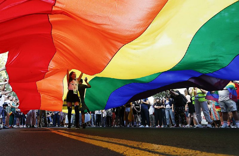 Participants walk Sunday under a rainbow flag during the annual gay pride parade in Belgrade, Serbia. 