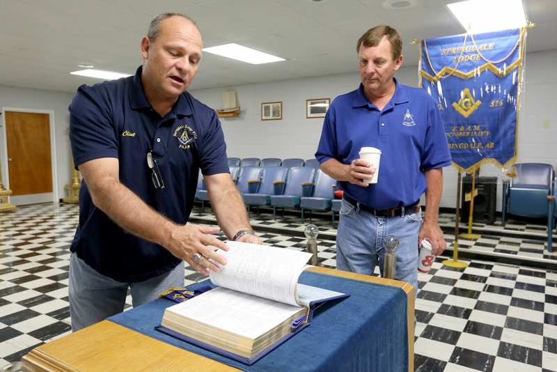 NWA Democrat-Gazette/DAVID GOTTSCHALK Clint Chastain and Tom Freking, both members of Springdale's Masonic Lodge, look Wednesday at the Bible in the center of the Lodge Room. Springdale needs to purchase three properties, including the lodge at 316 Spring St., to build its new Criminal Justice Center. "To them it's a brick and mortar building," said David Williamson, a past master. "To us, it's a lot of history. Hundreds of Springdale men have gone through this lodge."