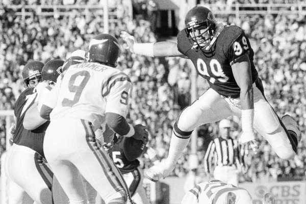 Chicago Bears tackle Dan Hampton leaps over a downed Minnesota Viking to corner quarterback Tommy Kramer during game in Chicago on Sunday, Oct. 28, 1985. The Bears won, 27-7. It was the eighth straight victory for the undefeated team. (AP Photo/Charles Bennett)