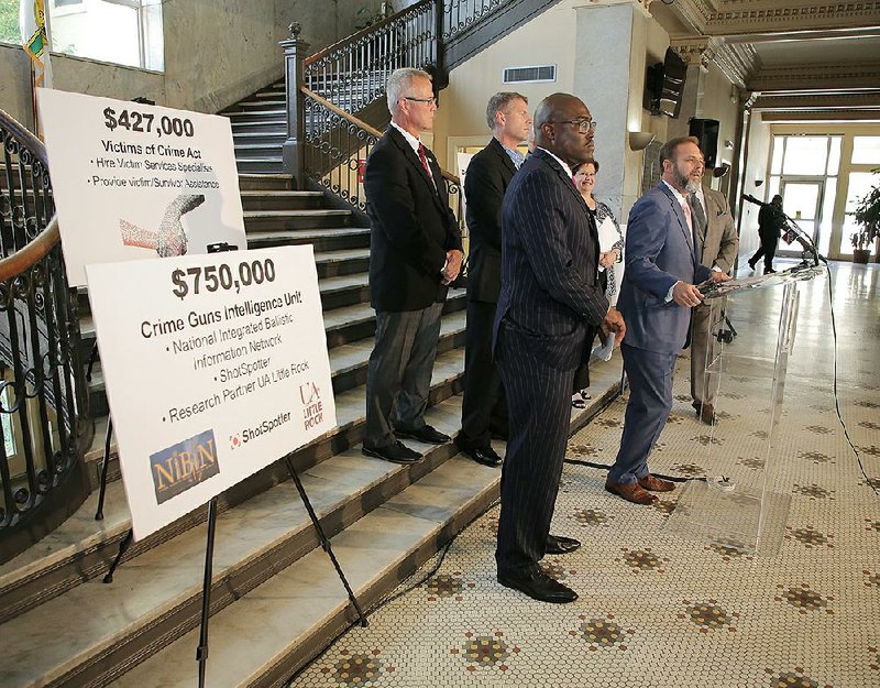 Cody Hiland (right), U.S. attorney for the Eastern District of Arkansas, discusses the public safety grants Monday during a news conference at Little Rock’s City Hall. Mayor Frank Scott Jr. (front) and other officials also made remarks. 