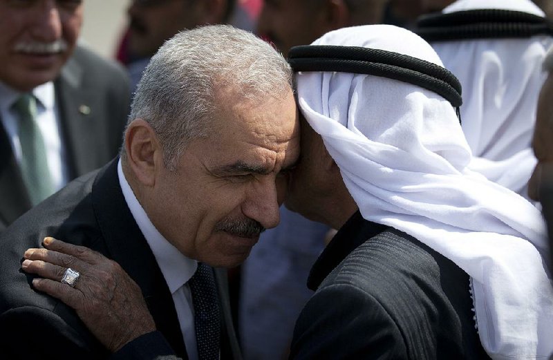 Palestinian Authority Prime Minister Mohammed Shtayyeh (left) greets others as he arrives Monday at a Cabinet meeting in the West Bank village of Fasayil. 