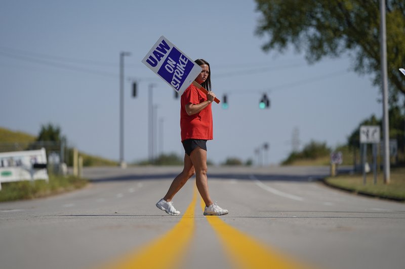 The Associated Press PLANT WORKER: Temporary plant worker Shanuel Merevith, of Edmonson County, Ky., carries a sign and walks the picket line outside the as General Motors assembly plant in Bowling Green, Ky, Monday. Thousands of members of the United Auto Workers walked off General Motors factory floors or set up picket lines early Monday as contract talks with the company deteriorated into a strike.