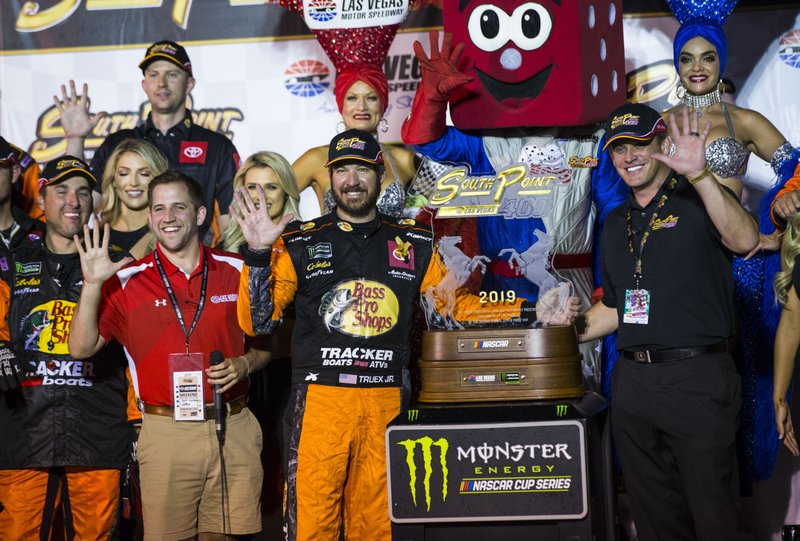 Martin Truex Jr. is presented with the trophy after winning a NASCAR Cup Series auto race at the Las Vegas Motor Speedway on Sunday, Sept. 15, 2019. (AP Photo/Chase Stevens)