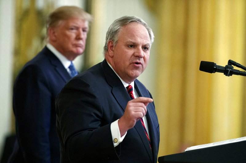 In this July 8, 2019, file photo President Donald Trump listens as then-Secretary of the Interior David Bernhardt speaks during an event on the environment in the East Room of the White House in Washington. In less than three years, Trump has named more former lobbyists to Cabinet-level posts than his most recent predecessors did in eight, putting a substantial amount of oversight in the hands of people with ties to the industries they're regulating. (AP Photo/Evan Vucci, File)