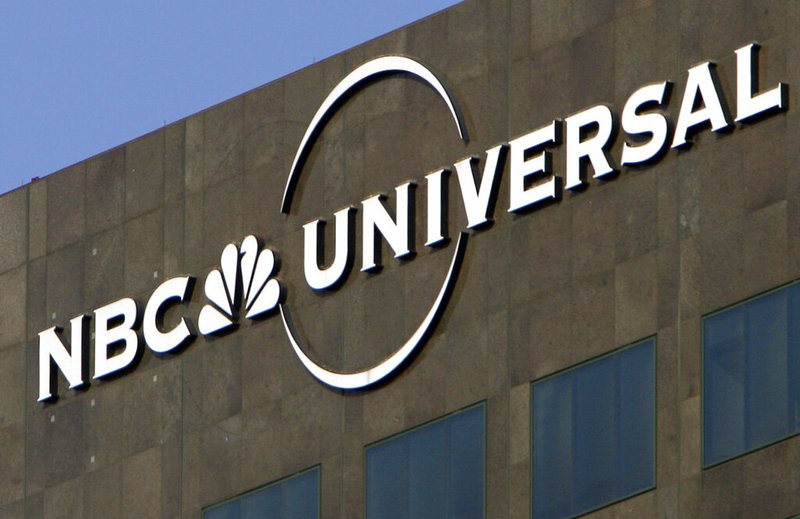 This Dec. 3, 2009, file photo, the NBC Universal logo hangs on a building in Los Angeles. Comcast's NBCUniversal says its upcoming streaming service will be called Peacock, in an homage to NBC's logo, and will be the home for some of the company's most popular shows, including "Parks and Recreation," "The Office" and "30 Rock." (AP Photo/Jae C. Hong, File)