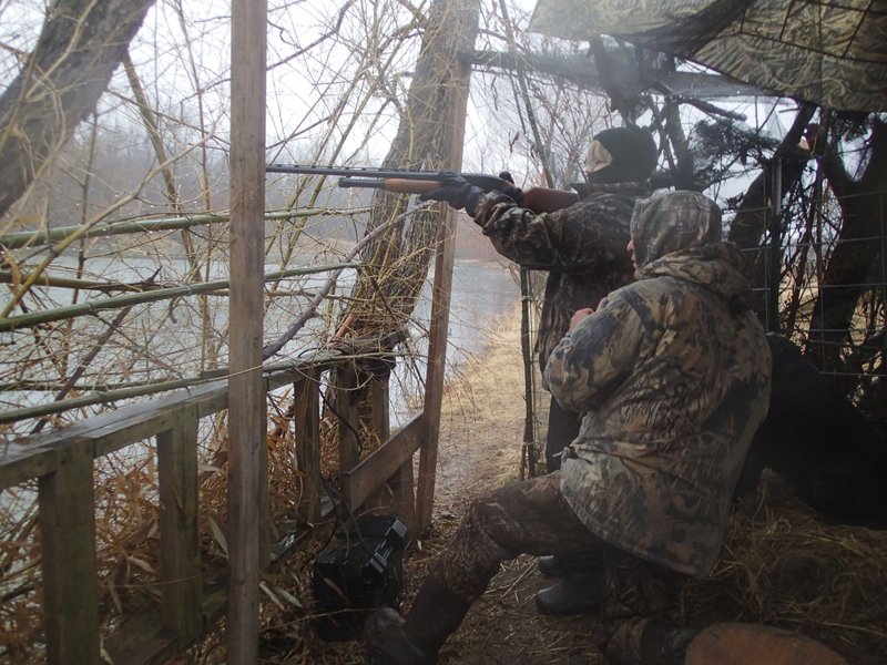 Matthew Shepard lines up a shot on a duck with help from Joe Falcon, right, who organized the duck hunt on Saturday Feb. 1 2014 for several young hunters, accompanied by their dads.