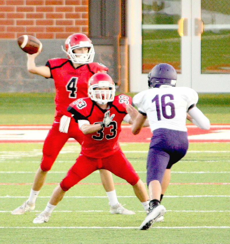 MARK HUMPHREY ENTERPRISE-LEADER Farmington freshman quarterback Cameron Vanzant stands in the pocket behind the pass protection of tailback Landyn Faught. Vanzant completed a 23-yard touchdown pass to Sam Wells with 21 seconds remaining in the first half followed by a 2-point conversion throw to Peyton Funk to give the junior Cardinals their first win at the new sports complex on Monday, Sept. 9, 2019. Farmington defeated Fayetteville White by a score of 8-6.