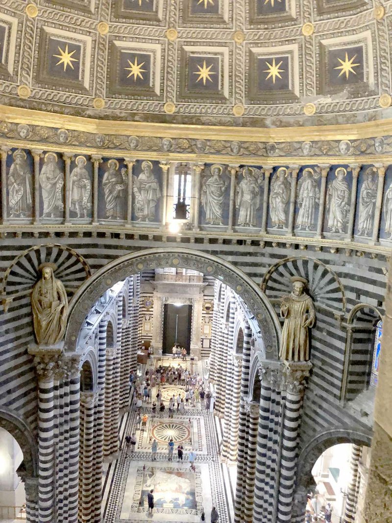 A clerestory view of the central nave of Siena&#x2019;s Duomo, a 13-century Gothic cathedral filled with statues, highly detailed marble floor mosaics, and paintings that include works by Pisano and Donatello.