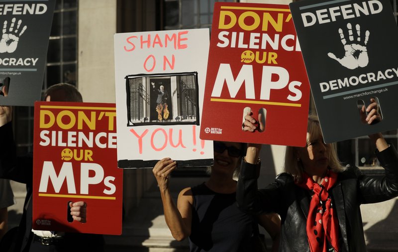 Protesters hold banners outside the Supreme Court in London, Tuesday Sept. 17, 2019. The Supreme Court is set to decide whether Prime Minister Boris Johnson broke the law when he suspended Parliament on Sept. 9, sending lawmakers home until Oct. 14 &#x2014; just over two weeks before the U.K. is due to leave the European Union. (AP Photo/Matt Dunham)