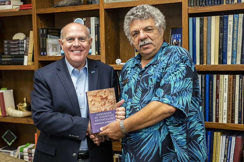 Dr. Trey Berry, president of Southern Arkansas University (left), congratulates Dr. Edward Kardas on the publication of the Handbook of Cognitive Archaeology: Psychology in Prehistory.