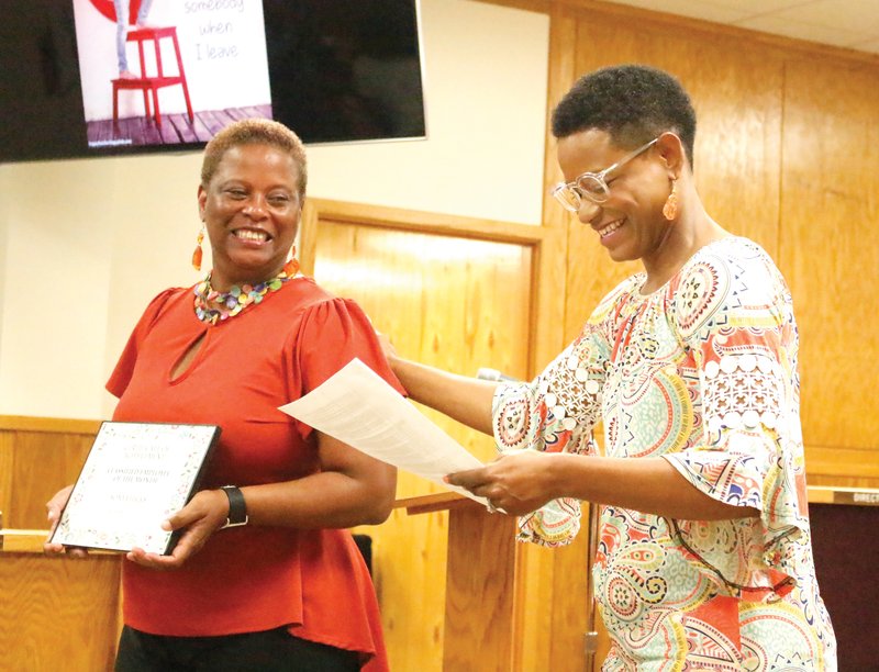 El Dorado School Board vice president Shaneil Yarbrough presents a classified employee of the month award to Sonya Hicks of Washington Middle School during the board's September meeting.