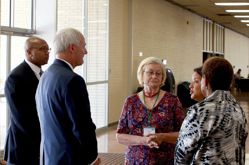 Gov. Asa Hutchinson (front), attending the Rural Rise Summit on Wednesday in Pine Bluff, visits with (from left) Ryan Whatley, Go Forward Pine Bluff director; Mary Pringos, a Go Forward Pine Bluff member; Mildred Franco, director of The Generator, an innovation hub; and Pine Bluff Mayor Shirley Washington. 