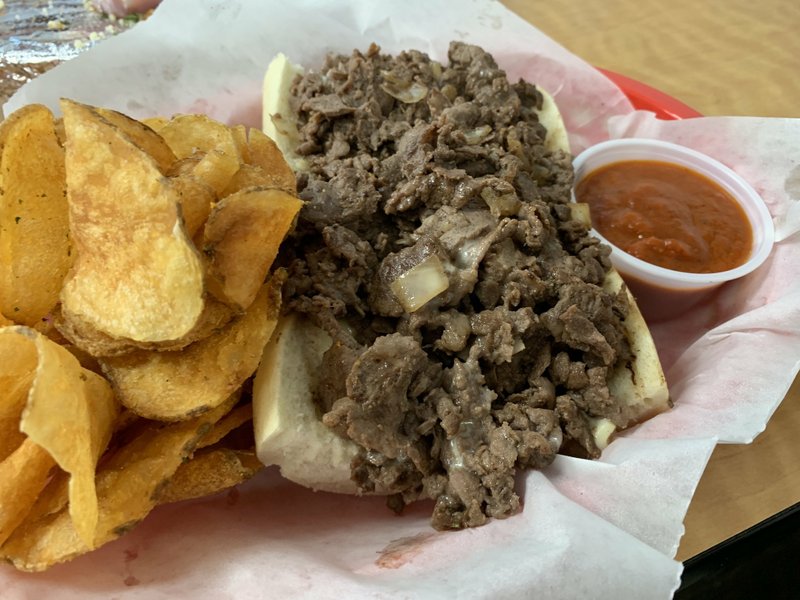 The kitchen chops the onions and melts white American cheese into the steak for the six-inch Philly cheesesteak at Rocky's on Country Club. It comes with a side of the house marinara sauce and kitchen-fried potato chips. Arkansas Democrat-Gazette/Eric E. Harrison