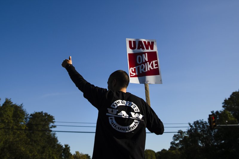 A worker gives the thumbs-up gesture to a passing motorist as he demonstratives outside a General Motors facility in Langhorne, Pa., Tuesday, Sept. 17, 2019. More than 49,000 members of the United Auto Workers walked off General Motors factory floors or set up picket lines early Monday as contract talks with the company deteriorated into a strike. (AP Photo/Matt Rourke)
