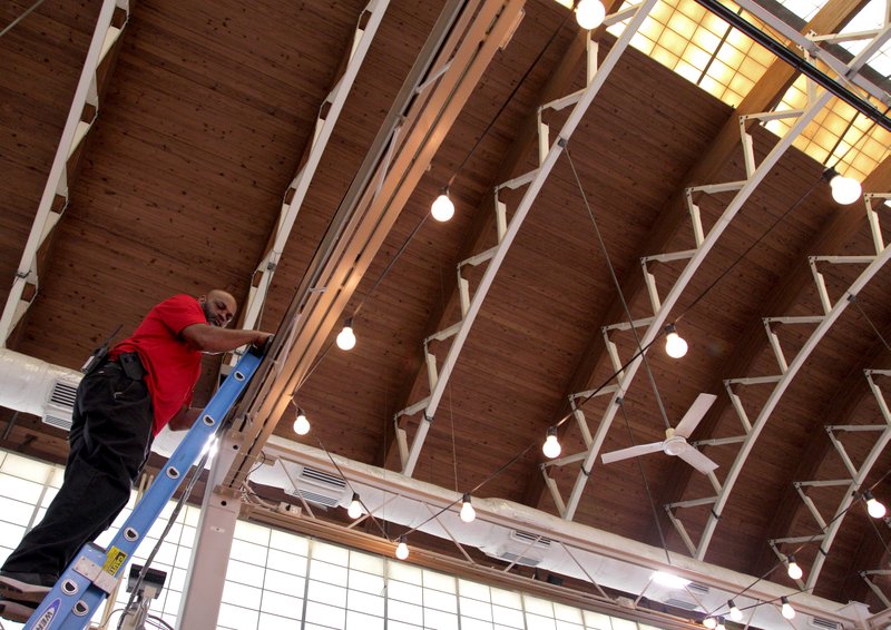 FILE — Little Rock Convention and Visitor Bureau employee Johnny Loney checks out some lights hanging above the River Market's Ottenheimer Market Hall in downtown Little Rock in this 2017 file photo.
