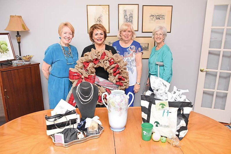 The Conway Symphony Orchestra Guild will host this year’s Jazz It Up fundraiser Oct. 3. Displaying a variety of items that will be up for bids are, from left, guild members Arlene Biebesheimer, Pam Strassle, Beverley Freiley and Betty Cohen. Items include an Arkansas Razorback wreath donated by Rena’s Custom Embroidery and Crafts; a package from Francis M. Fine Jewelry, including a Konstantino necklace, a Kate Spade purse and a gift certificate; a hand-painted porcelain urn by the late Madge Fite, donated by her daughter, Jody Bass, formerly of Conway; and a pet package donated by the St. Francis Dog Clinic.