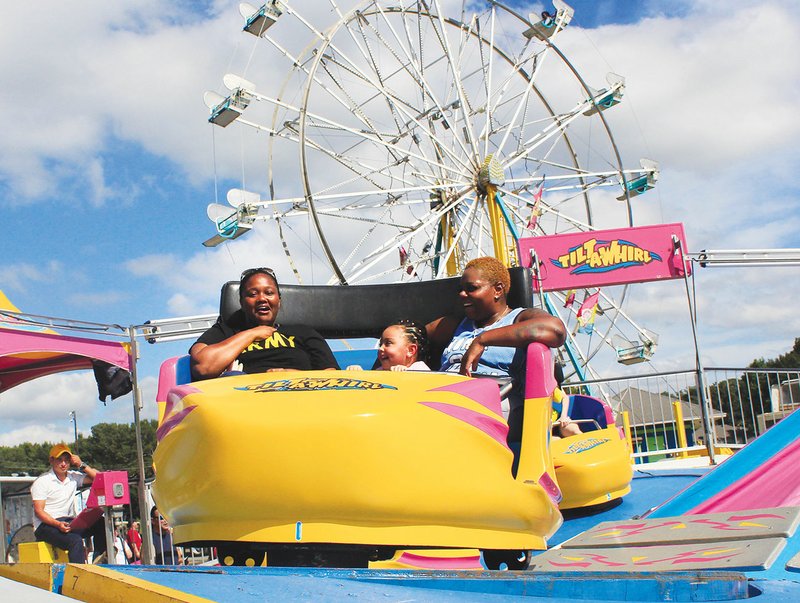 Latabra Marshall, left, of Jacksonville lets out a yell and clutches her chest after the Tilt-A-Whirl took a last quick spin to surprise her while Aniyah Lane, then 4, and Amika Lane of Jacksonville laugh in jest during the 2018 FestiVille at Dupree Park in Jacksonville. This year’s festival will take place Friday and Saturday.