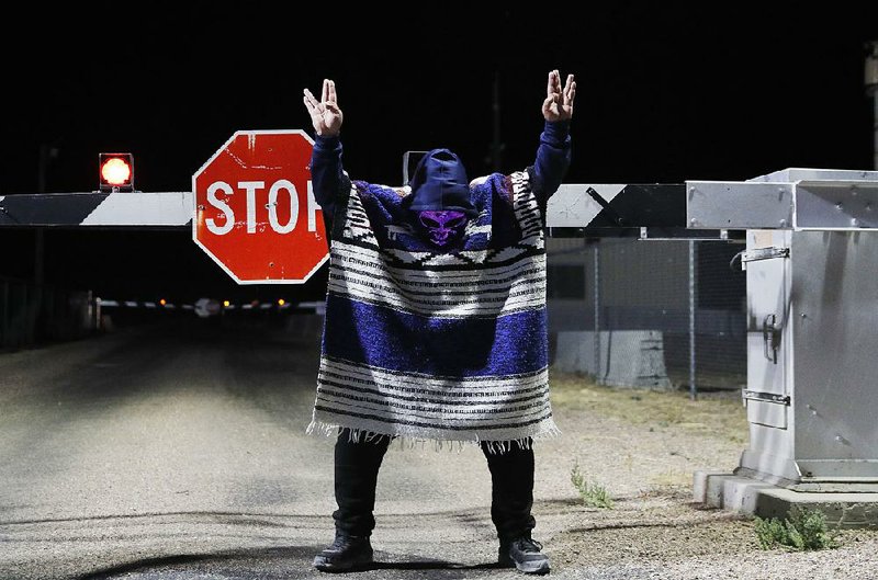 A man in an alien mask stands Friday at an entrance to the Nevada Test and Training Range near Area 51 outside Rachel, Nev., during the “Storm Area 51” revelry. For more photos, go to arkansasonline. com/921area51/ 