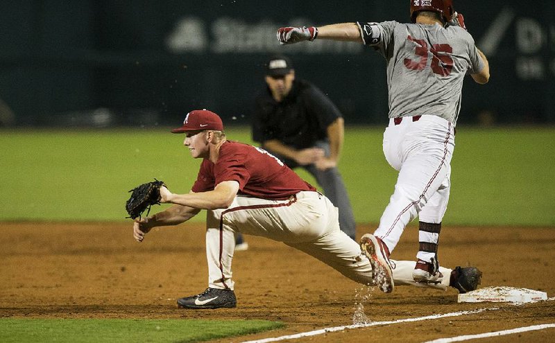 Arkansas first baseman Heston Kjerstad catches a throw from third as Oklahoma infielder Tyler Hardman comes down the first-base line. For more photos on the web, please go to www.arkansasonline. com/921hogsbaseball.