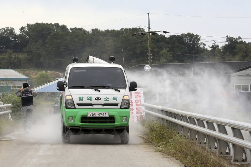 Disinfectant solution is sprayed from a vehicle as a precaution against African swine fever near a pig farm in Paju, South Korea, Friday, Sept. 20, 2019. South Korea said Friday that it is investigating two more suspected cases of African swine fever from farms near its border with North Korea, as fears grow over the spread of the illness that has decimated pig herds across Asia. (AP Photo/Ahn Young-joon)