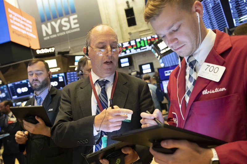 In this Sept. 16, 2019, file photo Gordon Charlop, center, and Christian Bader work at the New York Stock Exchange.  (AP Photo/Mark Lennihan, File)