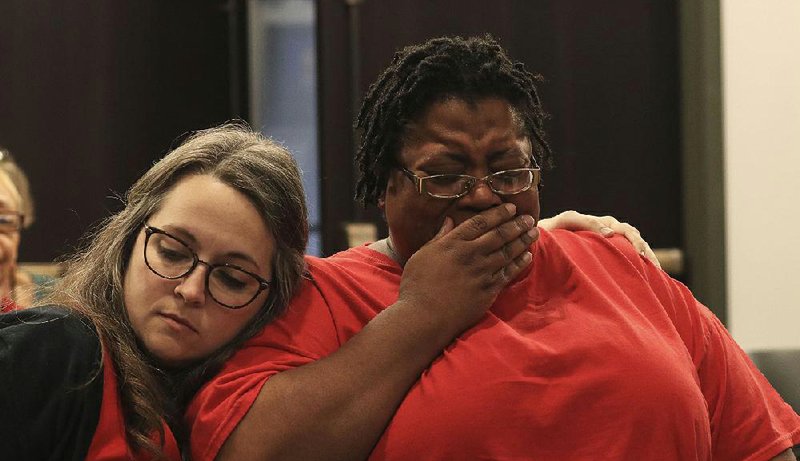 Kristen Alexander (left) comforts Valencia White at a state Board of Education meeting Friday during which board members voted to return the Little Rock School District to local control. More photos are available at arkansasonline.com/921board/. 