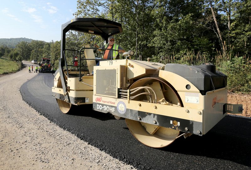 Andy Watson with Washington County’s road maintenance crew drives a roller Wednesday on Trace Branch Road, a section Washington County 32. The road crew is paving a 4-mile section.