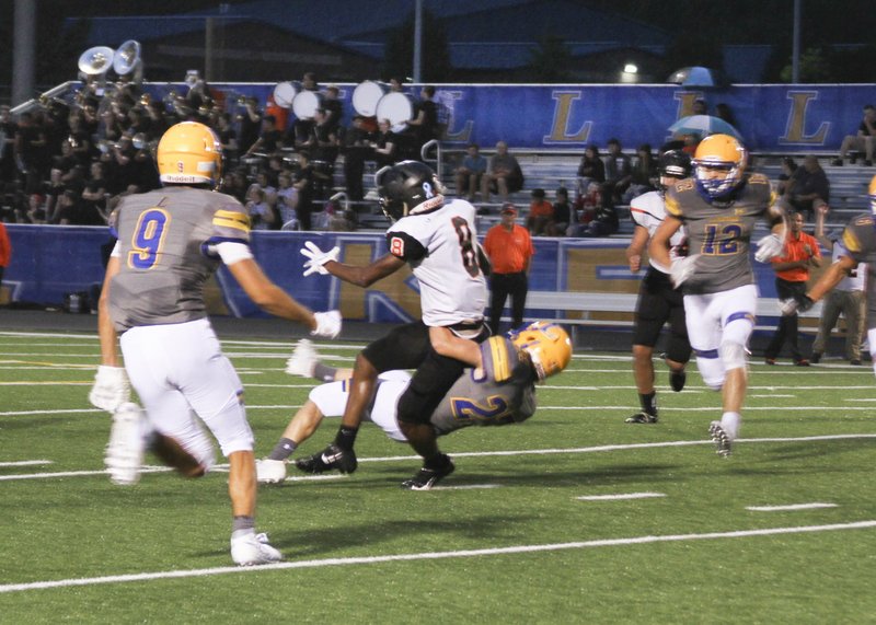 The Sentinel-Record/Jami Smith PULLING HIM DOWN: Lakeside junior safety Ryan Davis (27) takes down Malvern sophomore running back Marquez Johnson (8) during Friday night's game at Chick Austin Field. The Rams won 41-19.