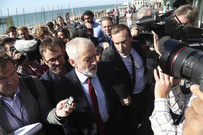 Labour Party leader Jeremy Corbyn, walking along the promenade, is met by the press on the way to the Labour Party Conference at the Brighton Centre in Brighton, England. Saturday Sept. 21, 2019. (Gareth Fuller/PA via AP)