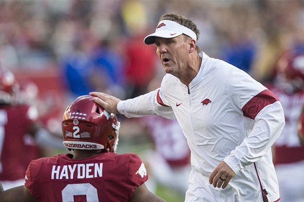 Arkansas coach Chad Morris taps the helmet of running back Chase Hayden prior to a game against San Jose State on Saturday, Sept. 21, 2019, in Fayetteville. 