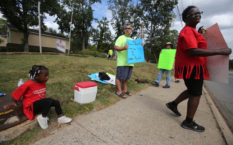 Bobbie Taylor (right), an organizer with Arkansas Renters United, stands with other protesters and residents on the sidewalk outside the Spanish Valley Apartments on Baseline Road on Sunday, Sept. 22, 2019, protesting poor living conditions at the Little Rock apartment complex. 