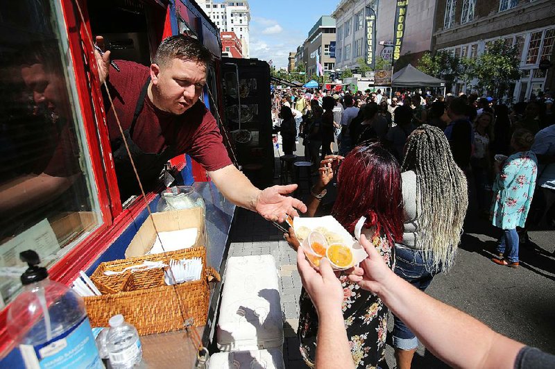 Arkansas Democrat-Gazette/THOMAS METTHE -- 9/22/2019 --
Kyler Nordeck, with the Katmandu Momo truck, hands a customer an order during the Main Street Food Truck Festival on Sunday, Sept. 22, 2019, in Little Rock. 
See more photos at www.arkansasonline.com/923foodtruck/