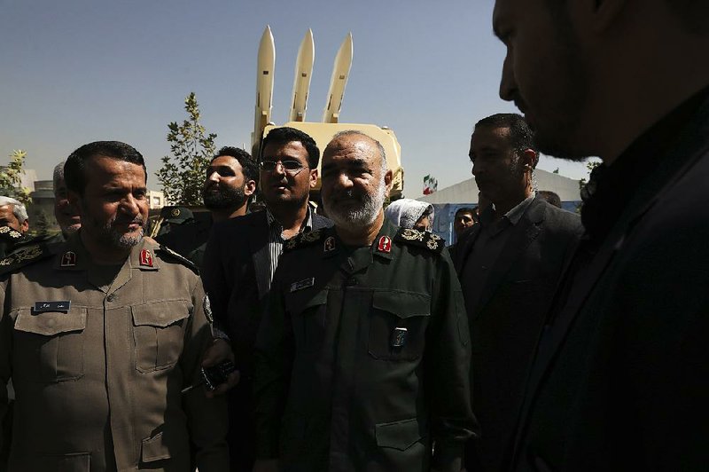 Gen. Hossein Salami (center), chief commander of Iran’s Revolutionary Guard, attends a Tehran ceremony on Saturday displaying the anti-missile system used to intercept a U.S. drone in June in the Strait of Hormuz. Salami declared his forces ready for combat, saying, “If anyone crosses our borders, we will hit them.” 