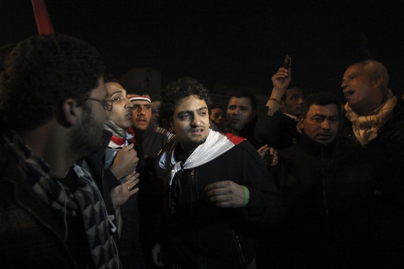 FILE - In this Feb. 10, 2011 file photo, Egyptian Wael Ghonim, center, walks into Tahrir Square after Egyptian President Hosni Mubarak's televised statement to his nation, in downtown Cairo, Egypt.  Ghonim said late Thursday, Sept. 19, 2019 in a video on his twitter account that authorities raided his parents' house in Cairo and arrested his brother Hazem, whom he described as &quot;a political person&quot; and confiscated his parents' passports. Ghonim alleges that the Egyptian embassy in the U.S. threatened him the previous day &quot;something will happen&quot; if he didn't stop criticizing Egypt's government on social media.  (AP Photo/Tara Todras-Whitehill)