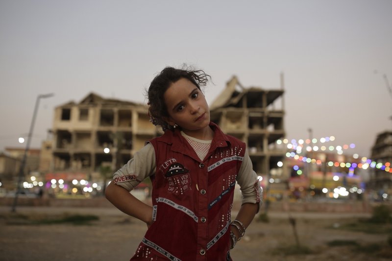 In this Thursday, Sept. 5, 2019, photo, Marwa, 10, poses for a portrait in a park near battle-ravaged buildings in Raqqa, Syria. Two years after the military offensive to oust the Islamic State group from its stronghold, Raqqa has been picking up the pieces. Officials say more than 800,000 people have returned to the city and its adjacent suburbs_ nearly eight times the residents who were left when the militants were finally expelled in Oct. 2017. (AP Photo/Maya Alleruzzo)