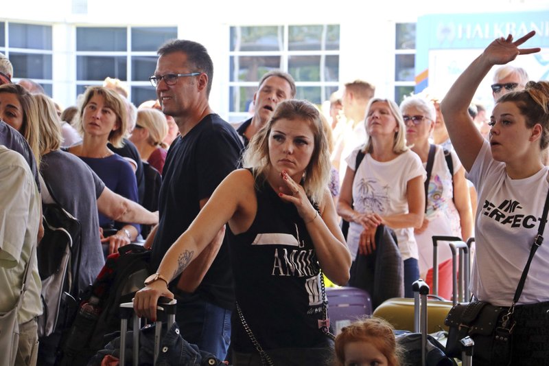 British passengers with Thomas Cook wait in queue at Antalya airport in Antalya, Turkey, Monday Sept. 23, 2019. Hundreds of thousands of travelers were stranded across the world Monday after British tour company Thomas Cook collapsed, immediately halting almost all its flights and hotel services and laying off all its employees. According to reports Monday morning some 21,000 Thomas Cook travellers were stranded in Turkey alone.(IHA via AP)

