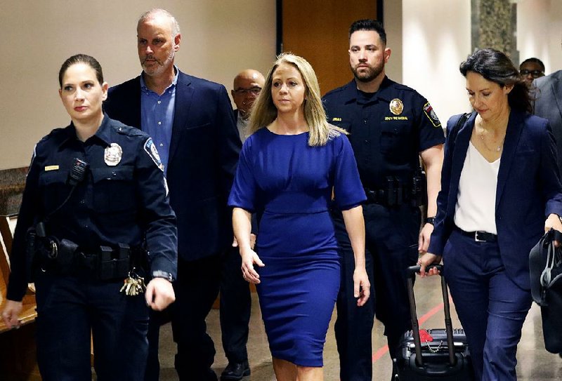 Former Dallas police officer Amber Guyger (center) arrives Monday for the first day of her murder trial in the 204th District Court at the Frank Crowley Courts Building in Dallas. Guyger is accused of shooting her black neighbor in his Dallas apartment.  