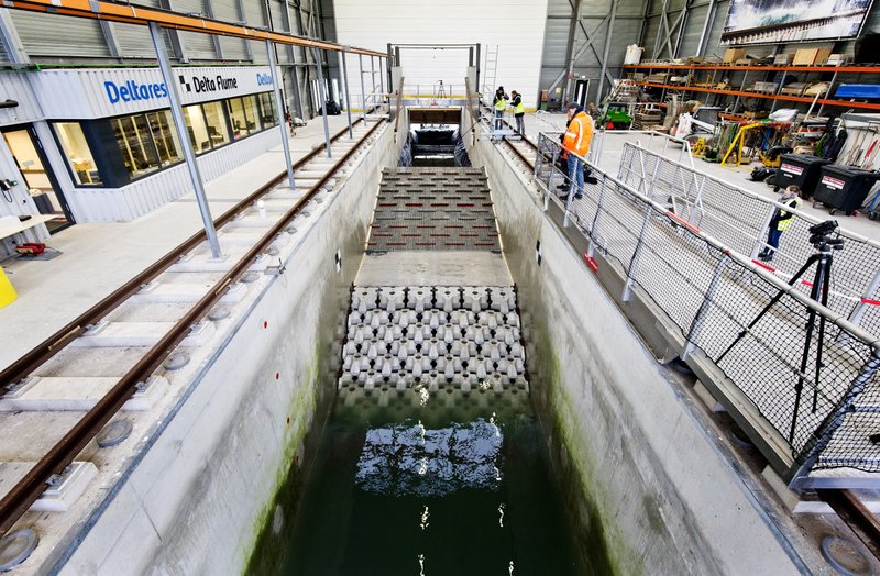 This photo taken in Jan. 2019 and made available by Deltares shows the flume wave tank in Delft, Netherlands, that is used to test structure designs for the strengthening work for the Afsluitdijk. With climate change bringing bigger storms and rising sea levels, one of the low-lying Netherlands&#x2019; key defenses against the sea is getting a major makeover. The 5-year project will see workers lay thousands of concrete blocks and raise parts of the 87-year-old Afsluititdijk dike. (Guus Schoonewille/Deltares via AP)