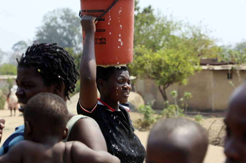 A woman heads home after fetching water at a borehole in Harare, Tuesday, Sept, 24, 2019.The more than 2 million residents of Zimbabwes capital and surrounding towns are now without water after authorities shut down the citys main treatment plant, raising new fears about disease after a recent cholera outbreak while the economy crumbles further.(AP Photo/Tsvangirayi Mukwazhi)