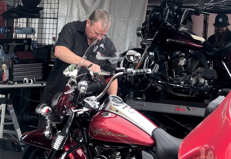 NWA Democrat-Gazette/ALEX GOLDEN Bob Willoughty of Syracuse, N.Y. installs a stereo into a Harley-Davidson motorcycle Thursday at the Bikes, Blues &amp; BBQ rally at Pig Trail Harley-Davidson in Rogers.