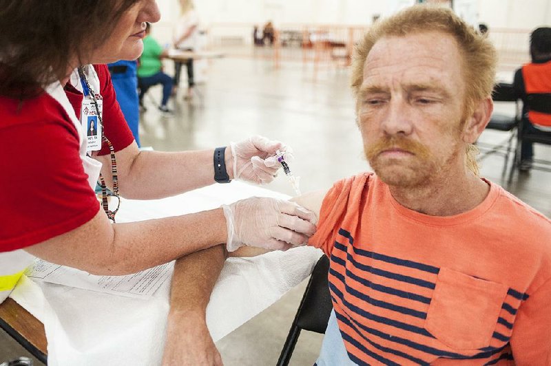 Arkansas Department of Health public health nurse Gwen Herlacher gives Rodney Scott a flu shot during the Mass Flu Vaccine Clinic at the State Fairgrounds in Little Rock in this Thursday, Sept. 26, 2019, file photo. More information about future dates for such clinics and public school clinics is available at healthy.arkansas.gov/programs-services/topics/influenza. 