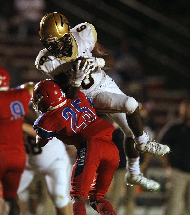 Hot Springs wide receiver Malik Brewer (6) pulls in a reception as he is hit by Little Rock McClellan safety Kendrick McCardell (25) during the second quarter on Thursday at McClellan High School in Little Rock. Photo by Thomas Metthe of the Arkansas Democrat-Gazette